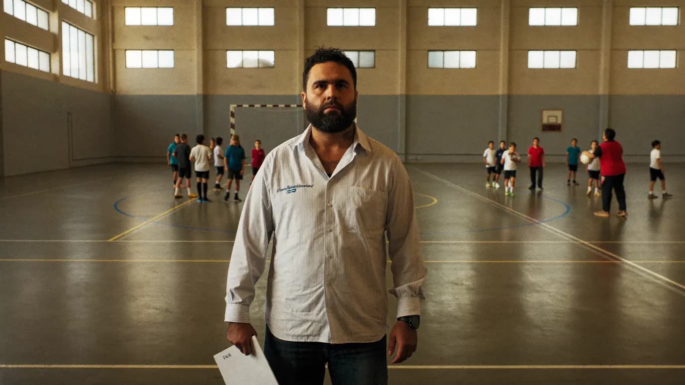 אבא צופה באימון כדוריד נוער בקבוצה קהילתית באולם ספורט בישראל